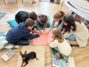 atelier_enfants_et_ados_de_art_therapie_en_train_de_dessiner_sur_des_feuilles_de_couleurs_et_le_petit_chien_chiwawa_lucky_regardant_lobjectif